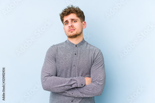 фотографія Young blond curly hair caucasian man isolated unhappy looking in camera with sarcastic expression