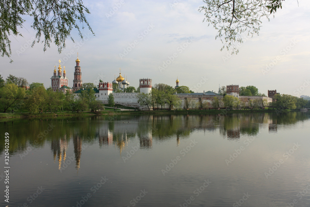 Novodevichy monastery in cloudy weather with reflections in summer evening, Moscow, Russia