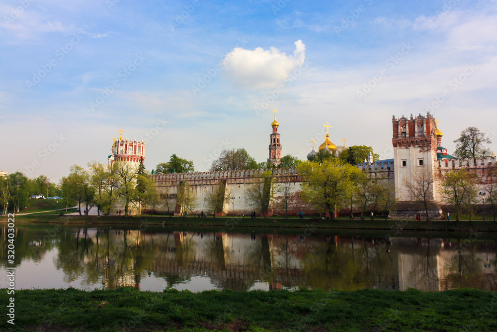 Fototapeta premium Novodevichy monastery in sunny weather with reflections in summer evening, Moscow, Russia