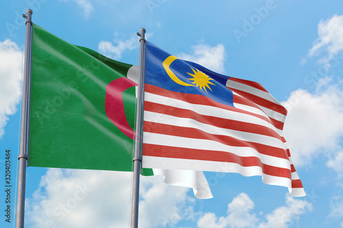 Malaysia and Algeria flags waving in the wind against white cloudy blue sky together. Diplomacy concept  international relations.