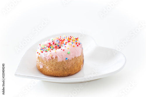 Heart Shaped plate with pink donut on white background