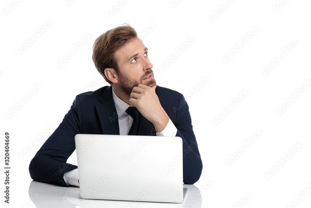 thoughtful young businessman holding hand to chin and thinking thoughtful young businessman holding hand to chin and thinking