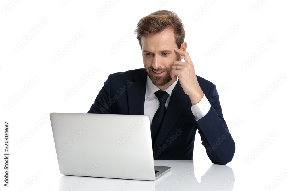 young businessman holding hand to temple and thinking young businessman holding hand to temple and thinking