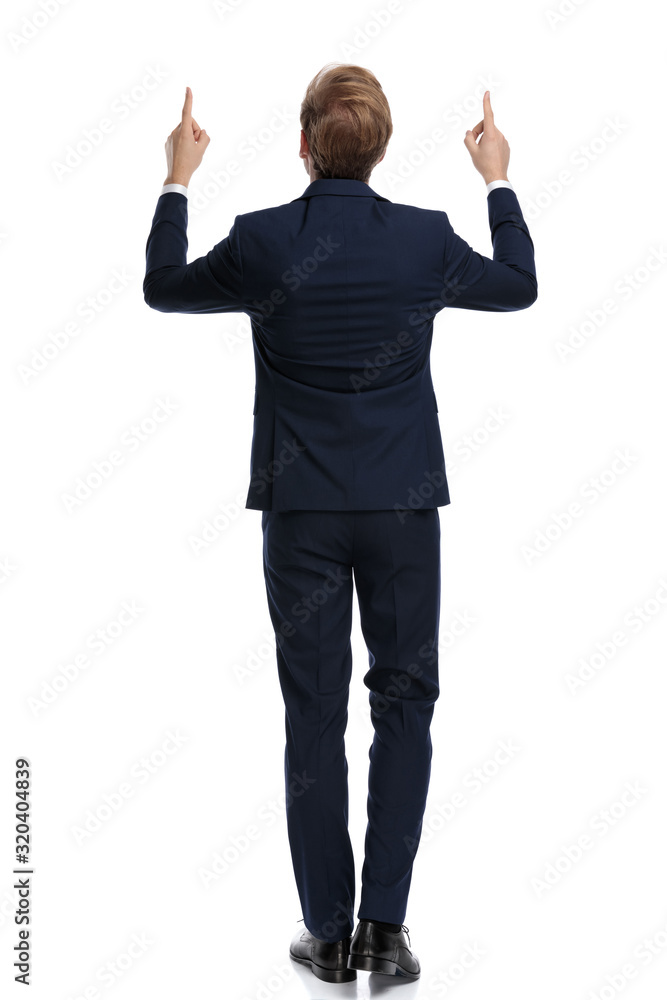 young businessman in navy blue suit pointing fingers up young businessman in navy blue suit pointing fingers up
