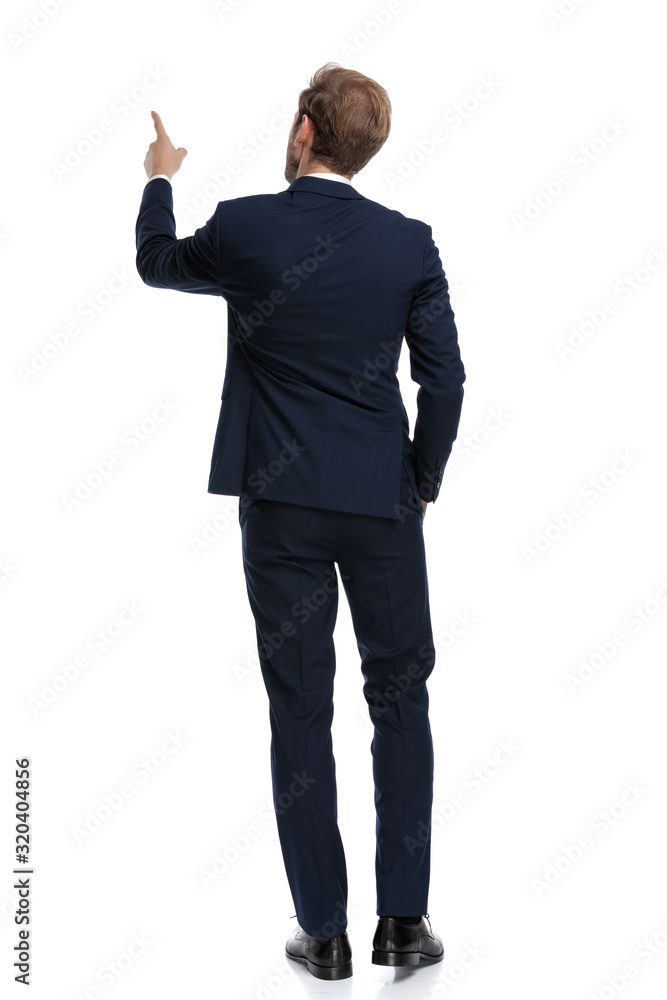 young businessman in navy blue suit pointing finger up young businessman in navy blue suit pointing finger up