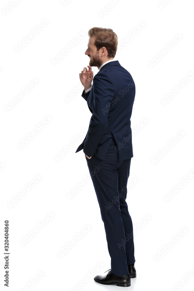 happy young businessman smiling and holding finger to chin happy young businessman smiling and holding finger to chin