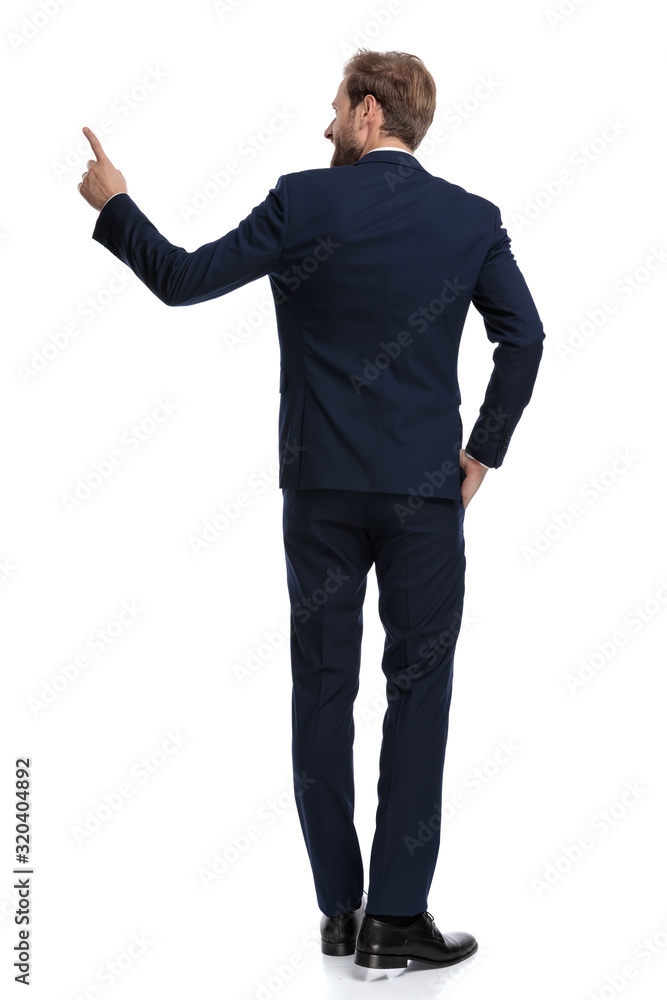 smiling bussinesman in navy blue suit pointing finger to side smiling bussinesman in navy blue suit pointing finger to side