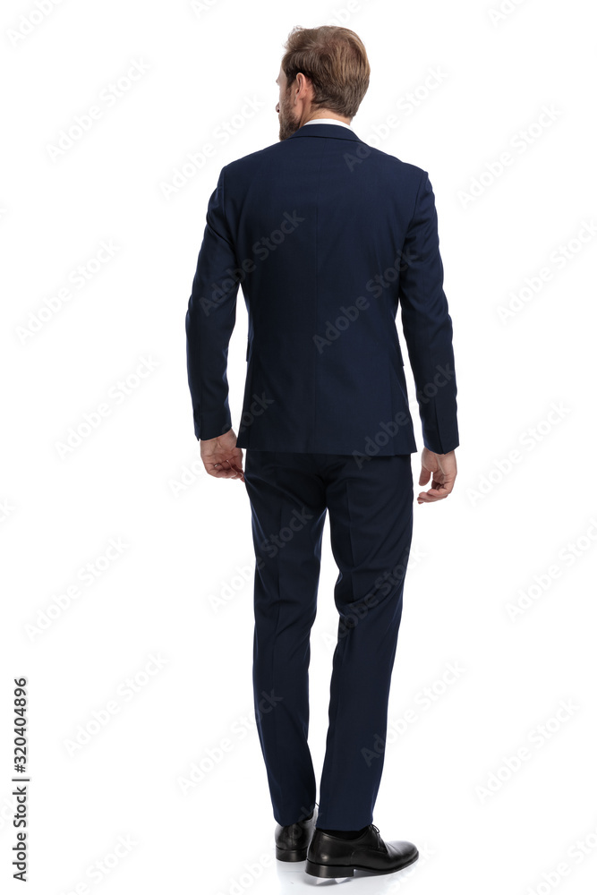 businessman in navy blue suit looking to side and walking businessman in navy blue suit looking to side and walking