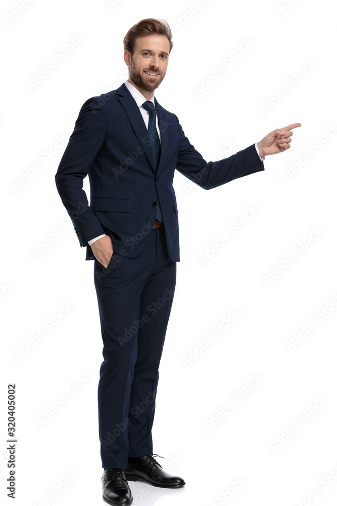 young businessman in navy blue suit pointing finger to side young businessman in navy blue suit pointing finger to side