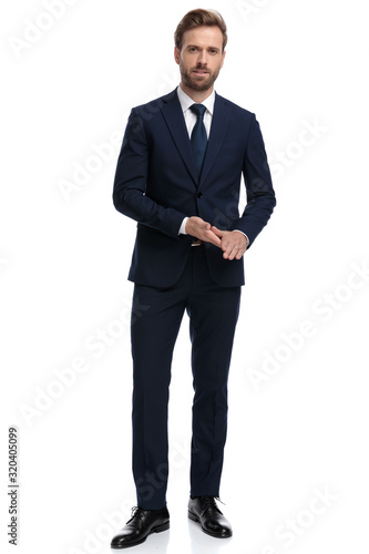 Wallpaper Mural young confident businessman in navy blue suit rubbing palms Torontodigital.ca