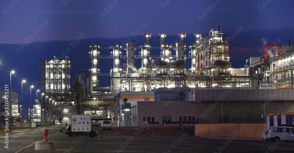 chemical factory at night with buildings, pipelines and lighting - industrial plant