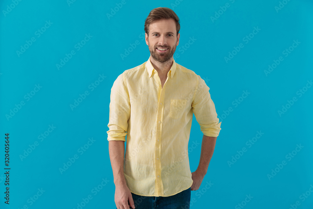 Casual man smiling with his hand in his rear pocket Casual man smiling with his hand in his rear pocket