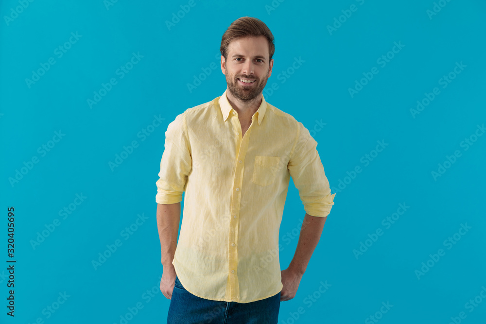 Positive casual man holding his hands in his back pockets Positive casual man holding his hands in his back pockets