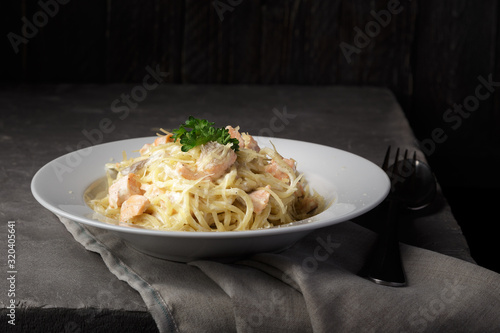 Traditional italian pasta. Spaghetti with salmon, cream cheese on a table. Homemade delicious italian traditional pasta on wooden table for dinner. italian cuisine.