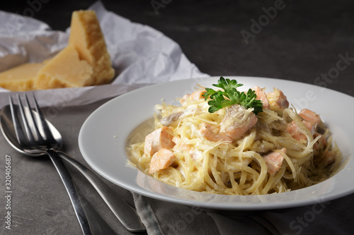 Traditional italian pasta. Spaghetti with salmon, cream cheese on a table. Homemade delicious italian traditional pasta on wooden table for dinner. italian cuisine.