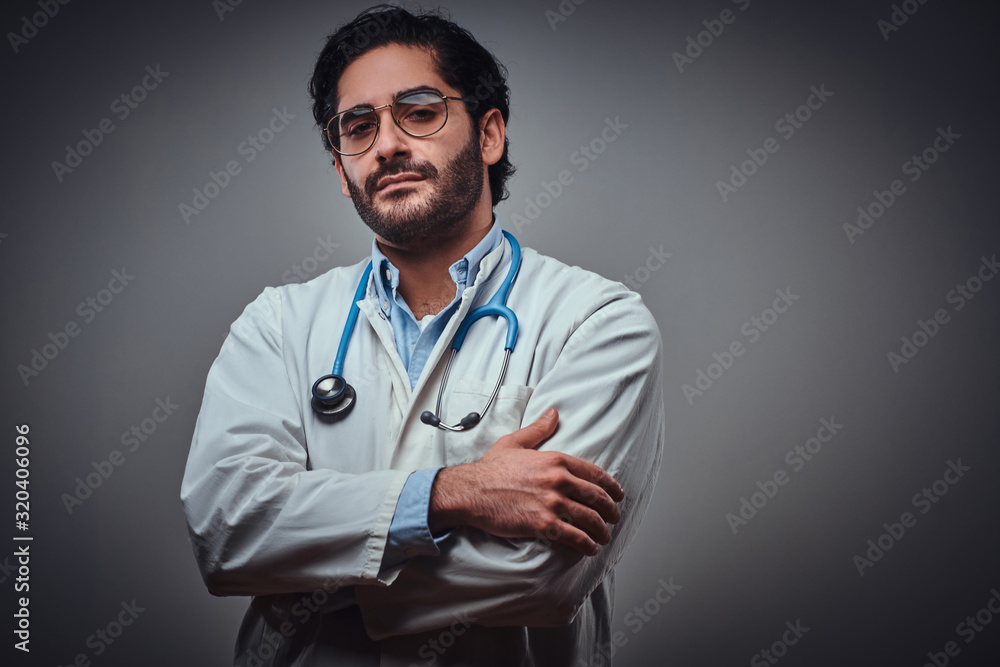 Pensive medic in glasses is posing for photographer at the photo studio. Pensive medic in glasses is posing for photographer at the photo studio.