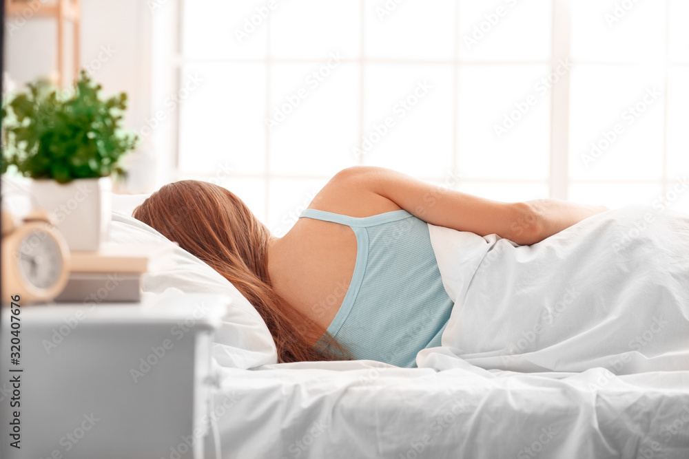 Morning at Home. Woman lying on bed sleeping back view Morning at Home. Woman lying on bed sleeping back view