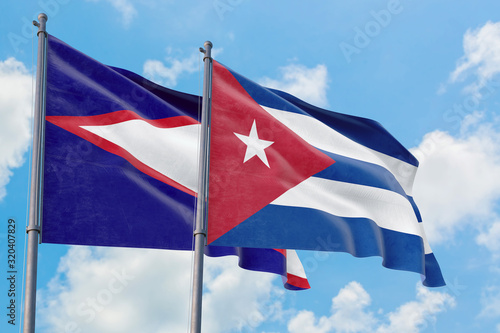 Cuba and American Samoa flags waving in the wind against white cloudy blue sky together. Diplomacy concept, international relations. photo