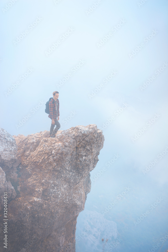 Young man standing on cliff