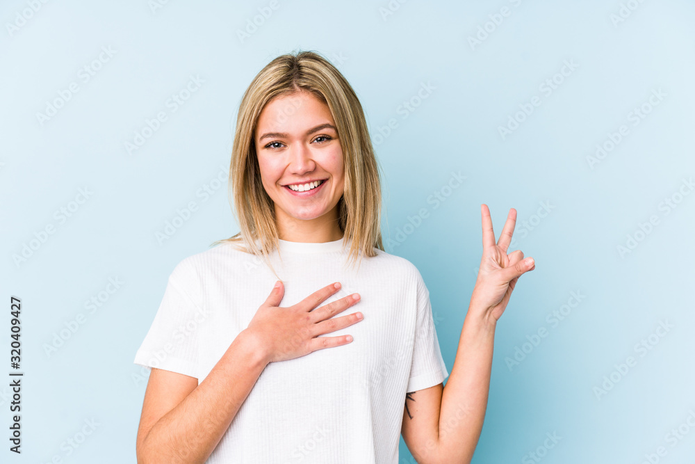 Young blonde caucasian woman isolated taking an oath, putting hand on chest. Young blonde caucasian woman isolated taking an oath, putting hand on chest.