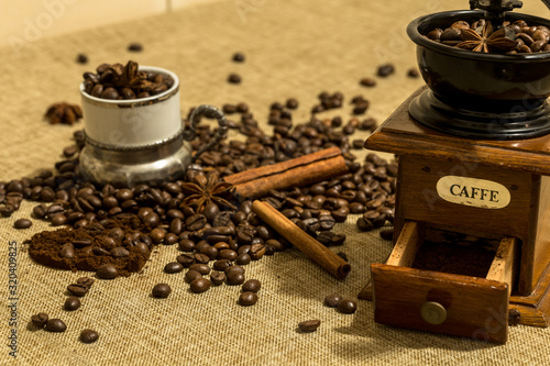 retro wooden manual coffee grinder coffee beans and a glass on a vintage tablecloth, heart-shaped ground coffee