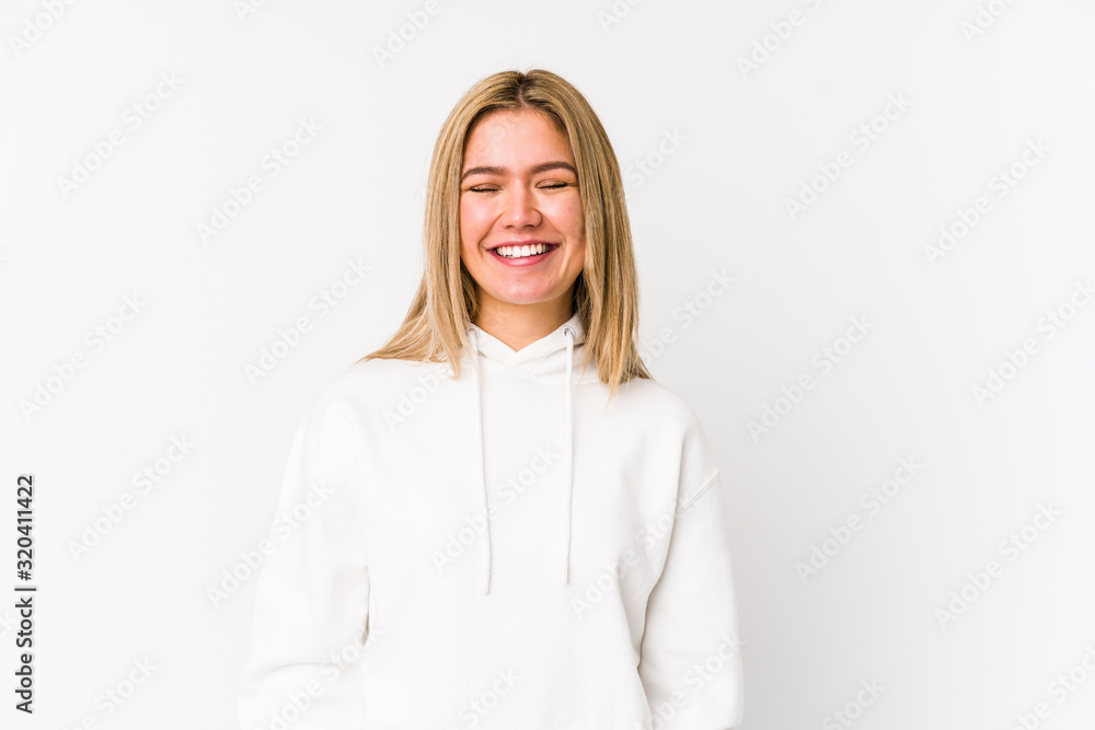 Young blonde caucasian woman isolated laughs and closes eyes, feels relaxed and happy. Young blonde caucasian woman isolated laughs and closes eyes, feels relaxed and happy.