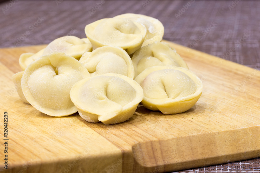 Traditional Russian dumplings hand-made on a cutting Board. Traditional Russian dumplings hand-made on a cutting Board.