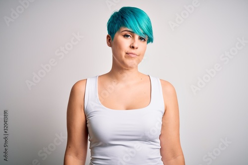 Young beautiful woman with blue fashion hair wearing casual t-shirt over white background looking sleepy and tired, exhausted for fatigue and hangover, lazy eyes in the morning.