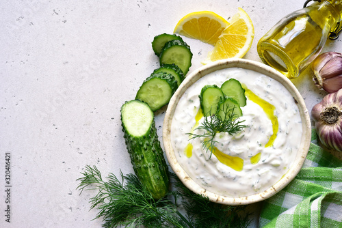 Tzatziki - traditional greek yogurt sauce in a bowl. Top view with copy space.
