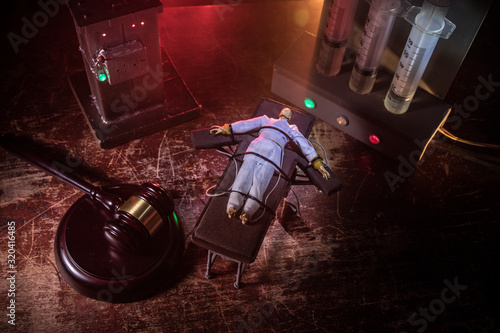 Prisoner handcuffed to death by lethal injection, vial with sodium thiopental and syringe on top of a table, conceptual image photo