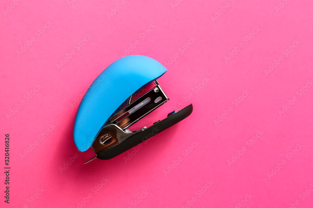 Office stapler on color background - obrazy, fototapety, plakaty 