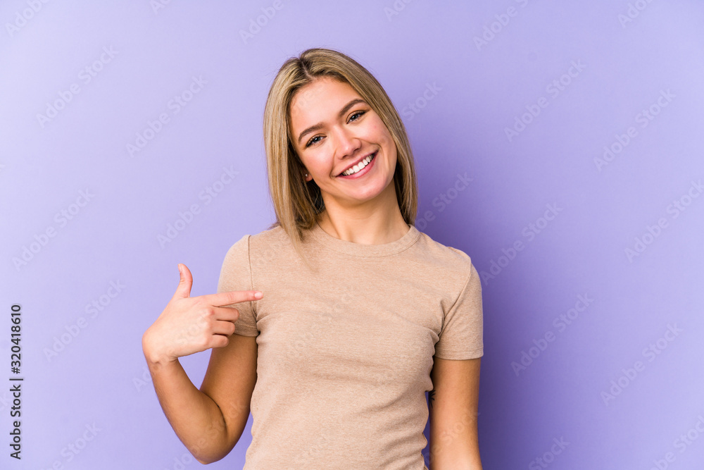Young blonde caucasian woman isolated person pointing by hand to a shirt copy space, proud and confident Young blonde caucasian woman isolated person pointing by hand to a shirt copy space, proud and confident