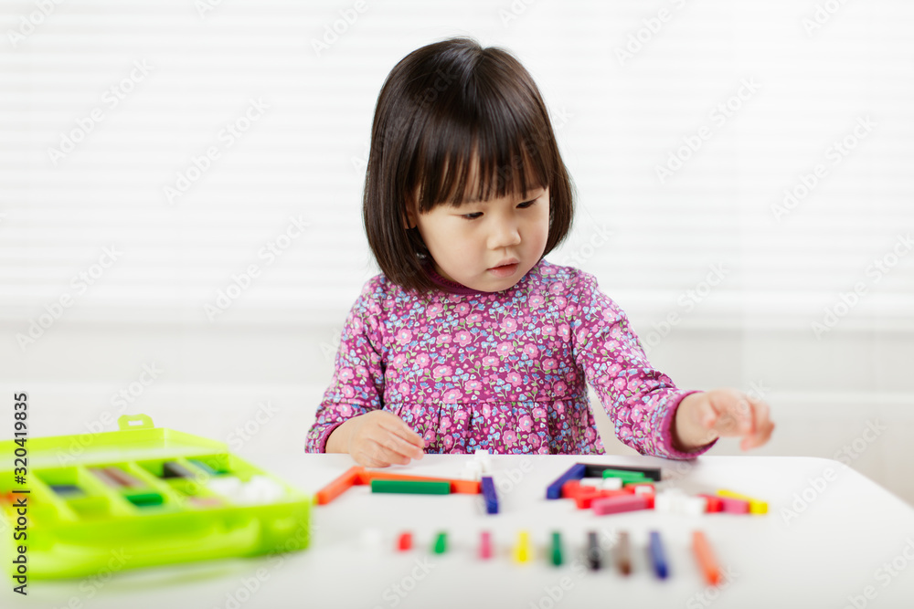 toddler girl playing creative toy blocks at home against white background toddler girl playing creative toy blocks at home against white background