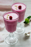 Berry-fruit mousse decorated with raspberries on a light background.