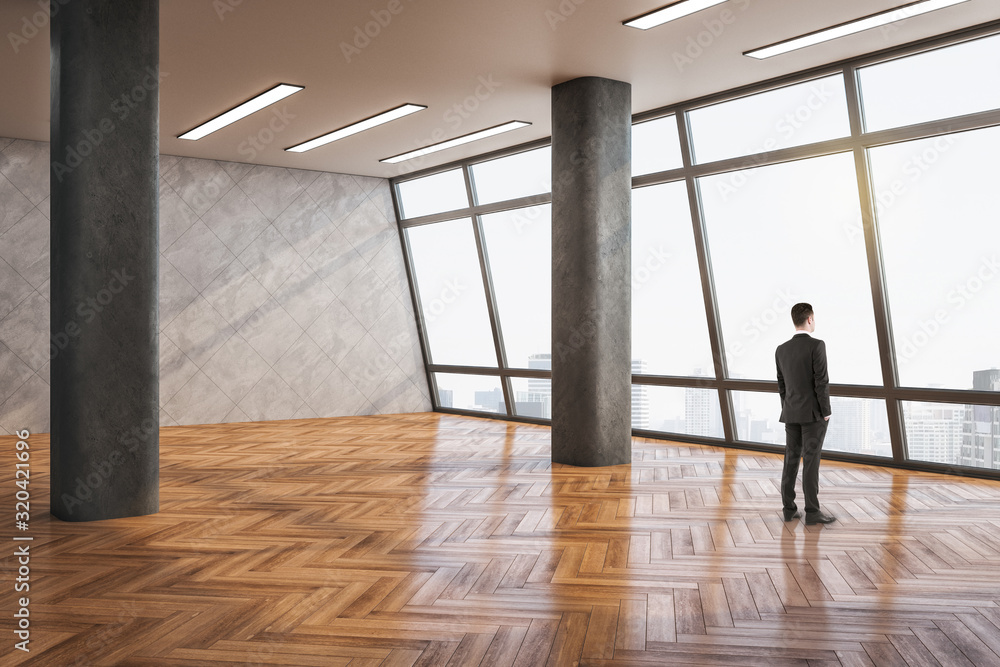 Businessman standing in minimalistic gallery interior Businessman standing in minimalistic gallery interior