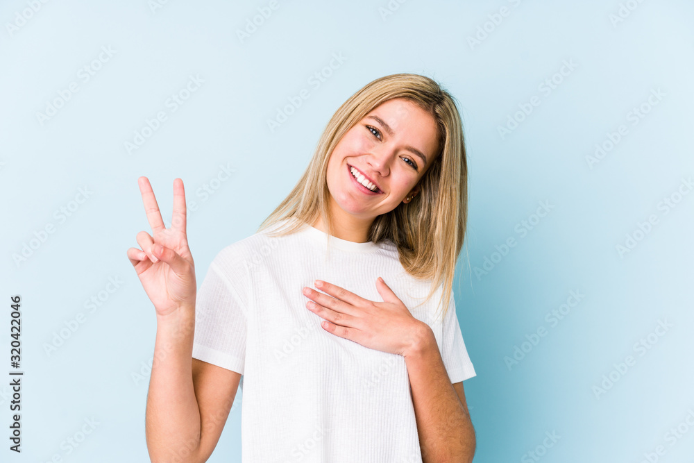 Young blonde caucasian woman isolated taking an oath, putting hand on chest. Young blonde caucasian woman isolated taking an oath, putting hand on chest.