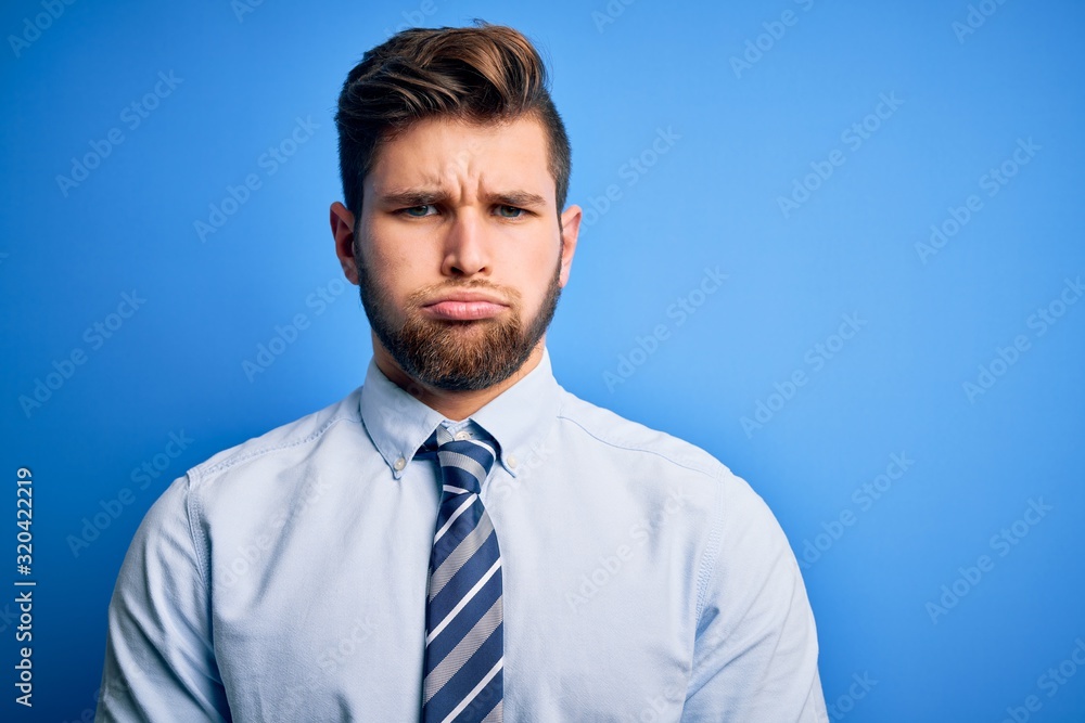 Young blond businessman with beard and blue eyes wearing elegant shirt and tie standing depressed and worry for distress, crying angry and afraid. Sad expression. Young blond businessman with beard and blue eyes wearing elegant shirt and tie standing depressed and worry for distress, crying angry and afraid. Sad expression.