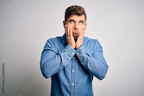 Young handsome blond man with beard and blue eyes wearing casual denim shirt Tired hands covering face, depression and sadness, upset and irritated for problem