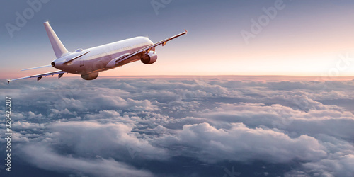Commercial airplane jetliner flying above dramatic clouds in beautiful light. Travel concept. photo