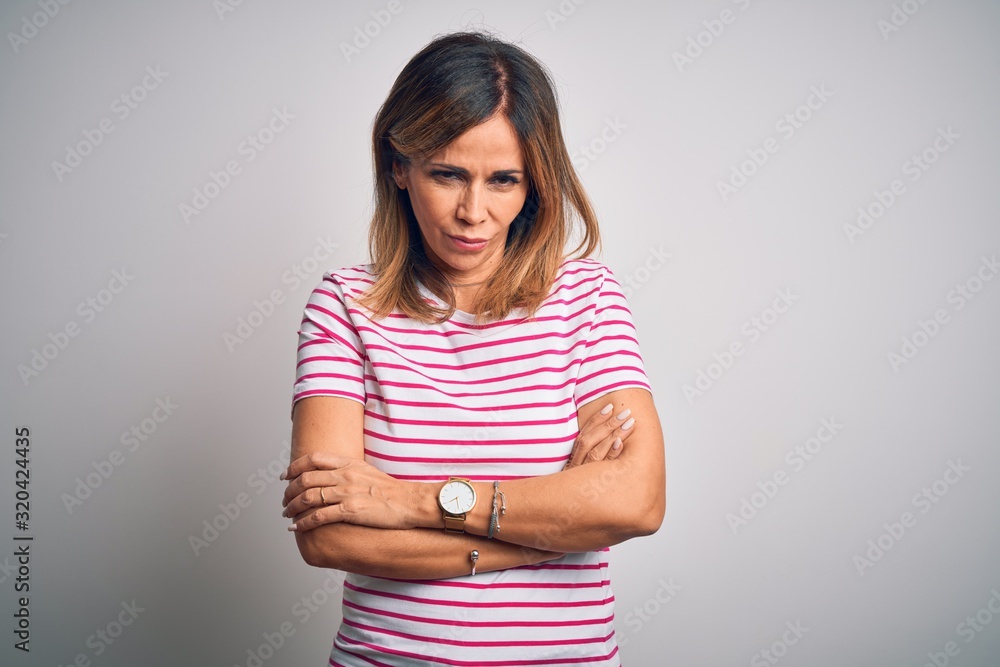 Middle age beautiful woman wearing casual striped t-shirt over isolated white background skeptic and nervous, disapproving expression on face with crossed arms. Negative person. Middle age beautiful woman wearing casual striped t-shirt over isolated white background skeptic and nervous, disapproving expression on face with crossed arms. Negative person.