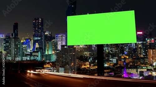 Time Lapse of Blank Billboard with a Green Screen on Night Street with light trails, city night background.