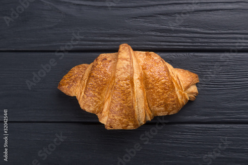 Croissants on a black wooden table. Croissant breakfast. Croissants on a wooden board and a black wooden table. Fresh French Baked Croissants. Warm Fresh Buttery Rolls. Free space for text. View from 