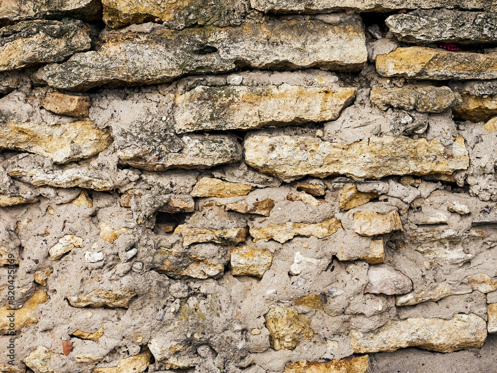 Old stone wall of colored stones close-up background texture Old stone wall of colored stones close-up background texture