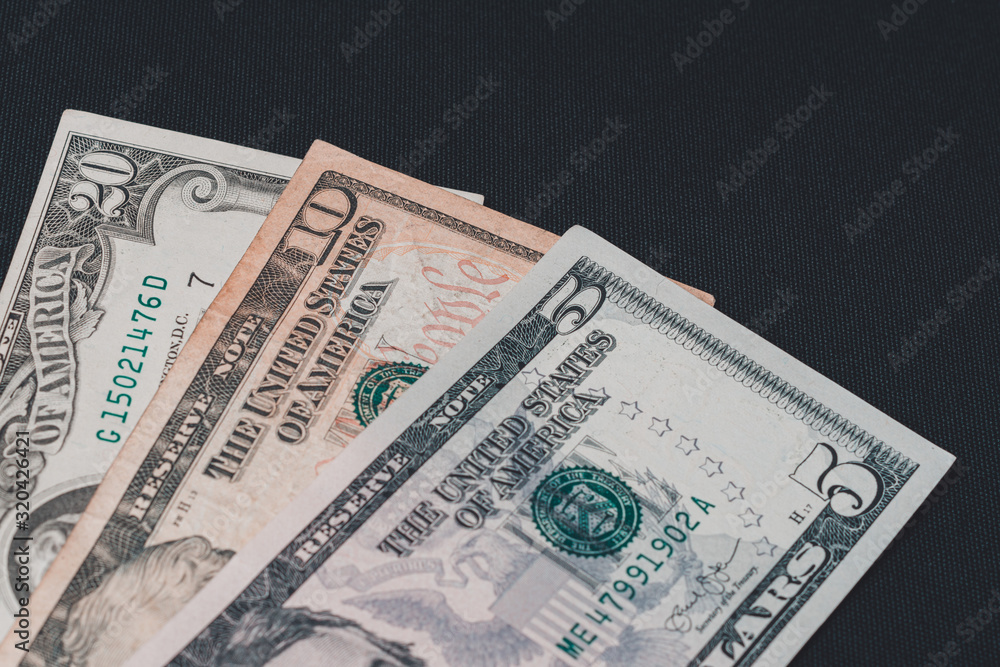 Composition of all US dollar notes stacked on a black background with space for copying. Composition of all US dollar notes stacked on a black background with space for copying.