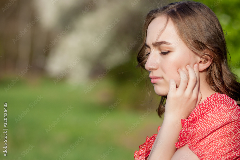 Close-up Of Female Hands Putting Hearing Aid In Ear. Modern digital in the ear hearing aid for deafness and the hard of hearing patients Close-up Of Female Hands Putting Hearing Aid In Ear. Modern digital in the ear hearing aid for deafness and the hard of hearing patients