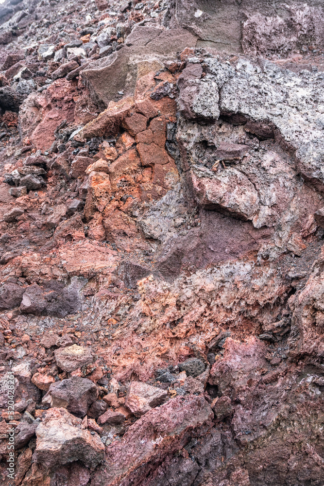 Leilani Estate, Hawaii, USA. - January 14, 2020: 2018 Kilauea volcano eruption hardened black lava field. Closeup portrait of inner red and brown pieces of layer.