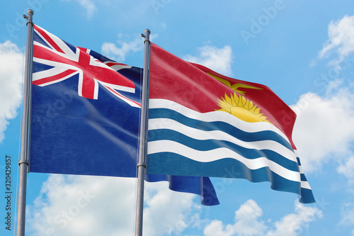 Kiribati and Anguilla flags waving in the wind against white cloudy blue sky together. Diplomacy concept, international relations.