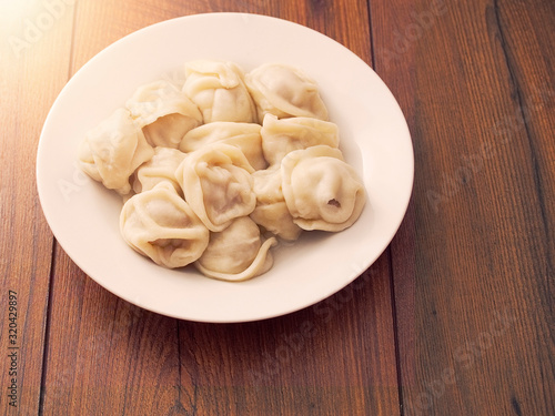 Serving of traditional East European dumplings on a white plate and wooden table.