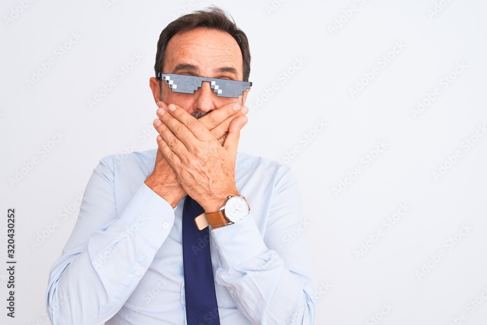 Middle age businessman wearing thug life sunglasses over isolated white background shocked covering mouth with hands for mistake. Secret concept. Middle age businessman wearing thug life sunglasses over isolated white background shocked covering mouth with hands for mistake. Secret concept.