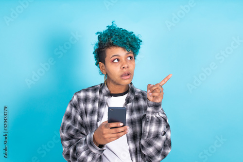 Quadro su tela african american girl or woman with mobile phone or smartphone isolated on blue